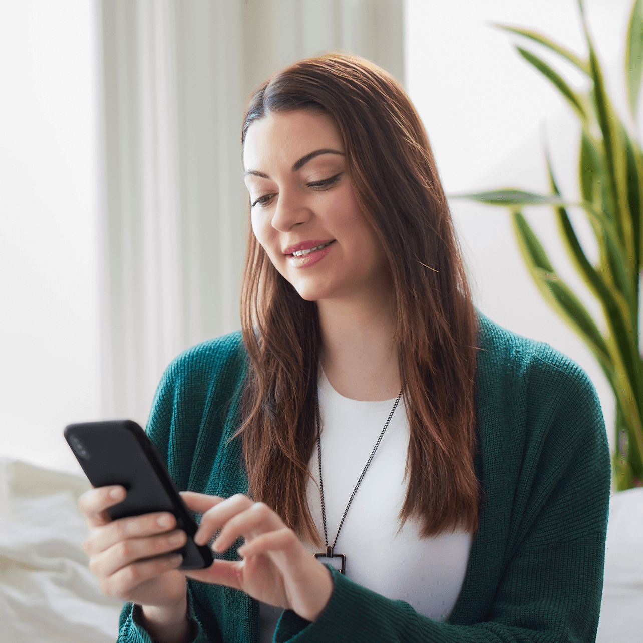 Woman smiling while using a smartphone